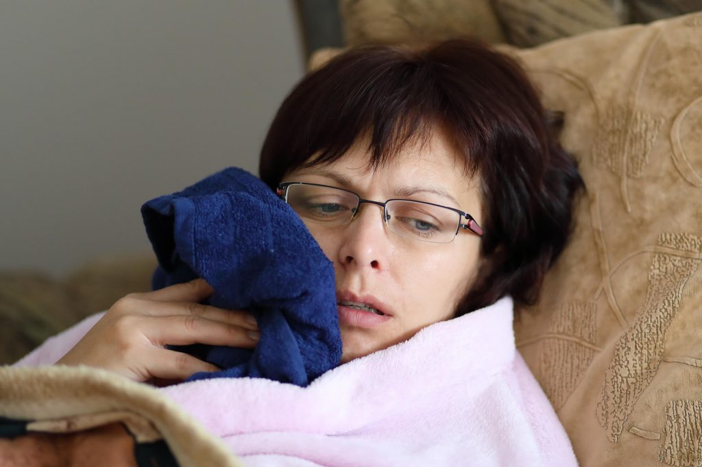 a patient applying cold compress after getting Wisdom Teeth Removal in Las Vegas
