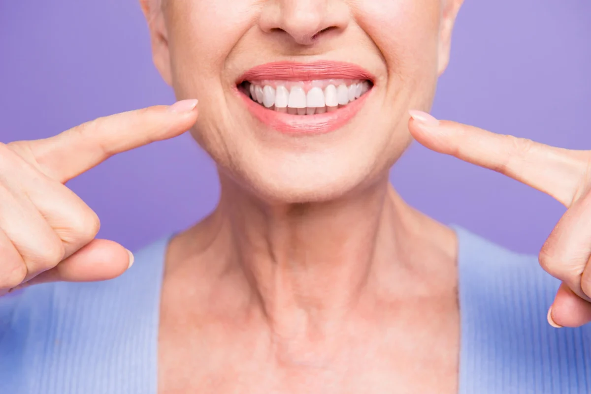 a senior woman pointing at her Affordable Dental Implants in Las Vegas