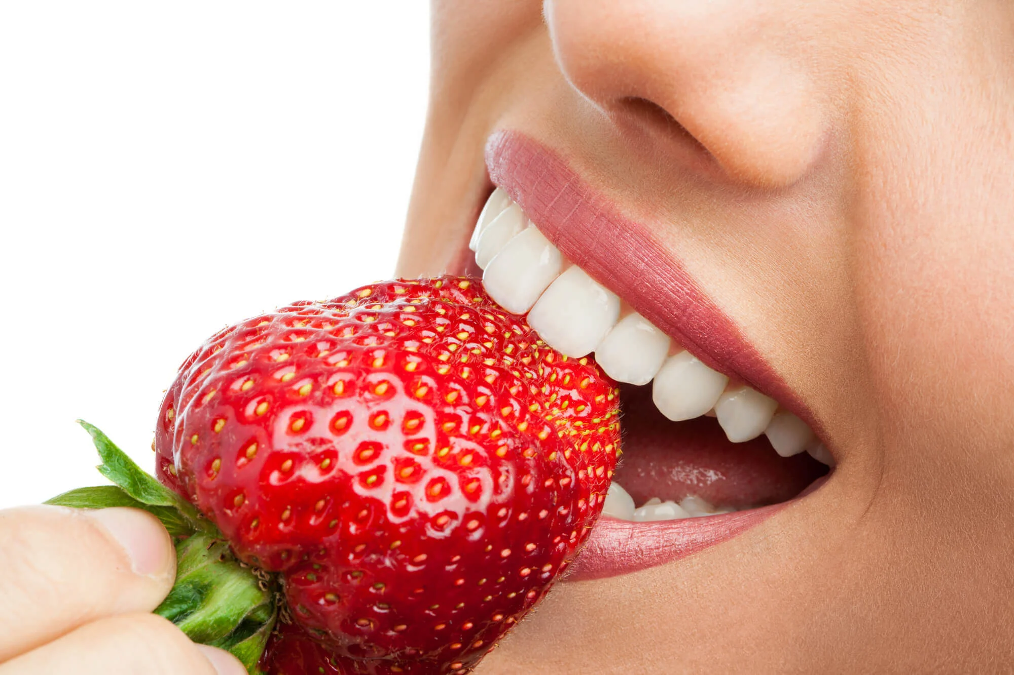 woman eats a strawberry instead of using it for Teeth Whitening in Las Vegas NV