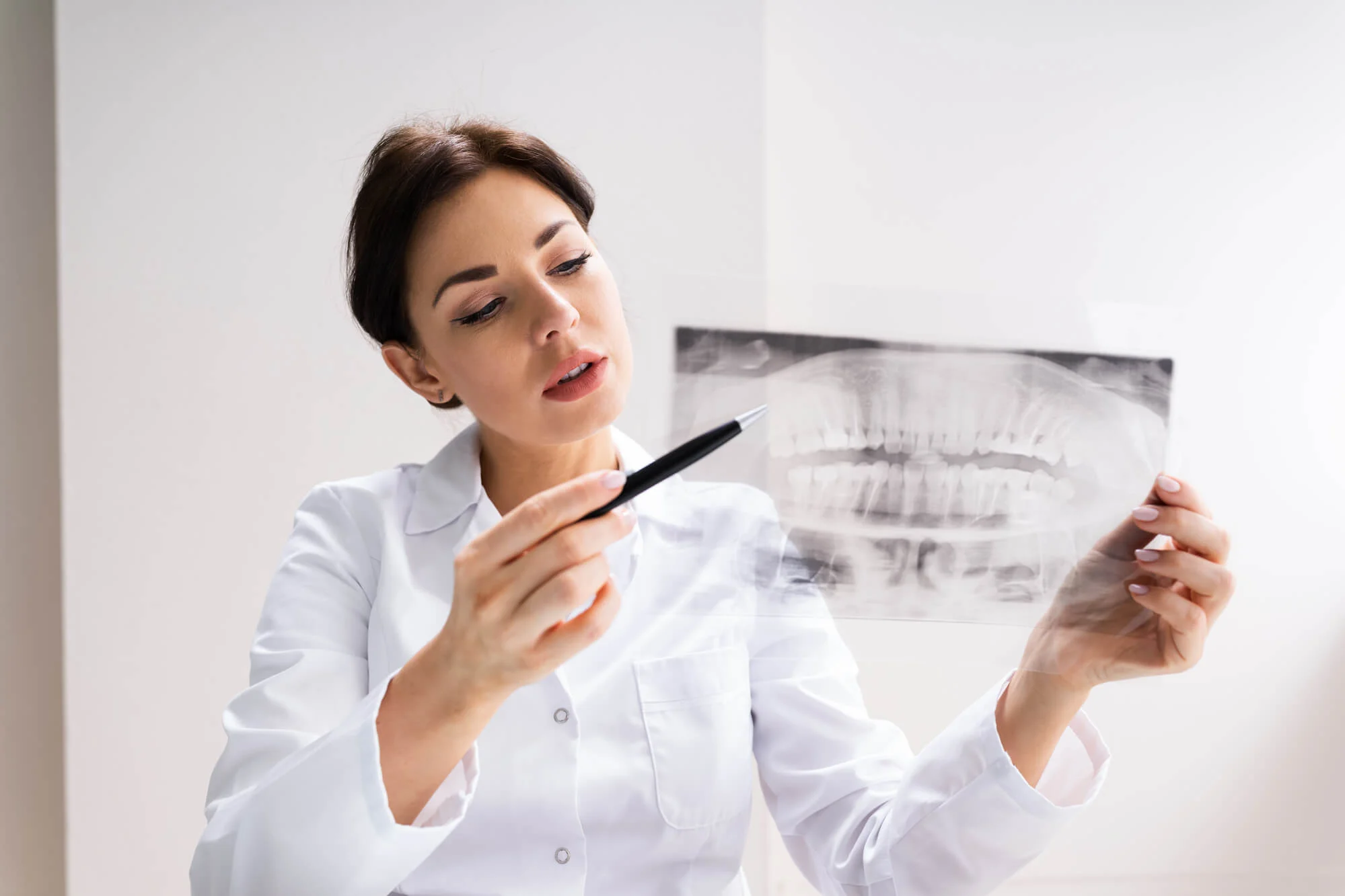 a dentist discussing Wisdom Teeth Removal in Las Vegas while holding an x-ray film