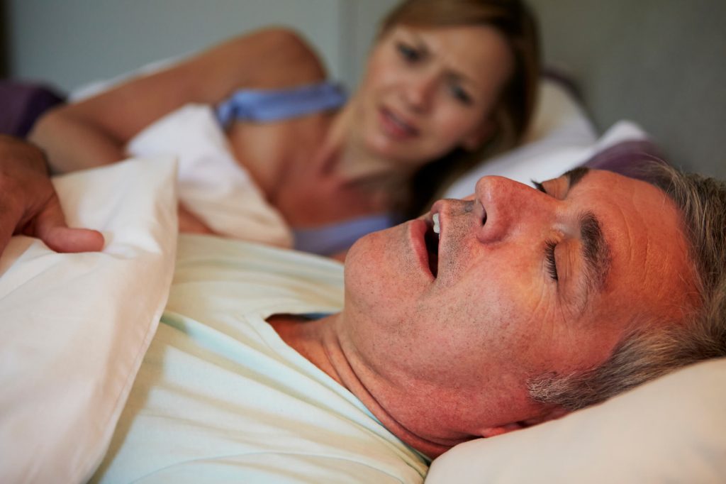 a man needing Sleep Apnea Treatment in Las Vegas keeping his wife awake
