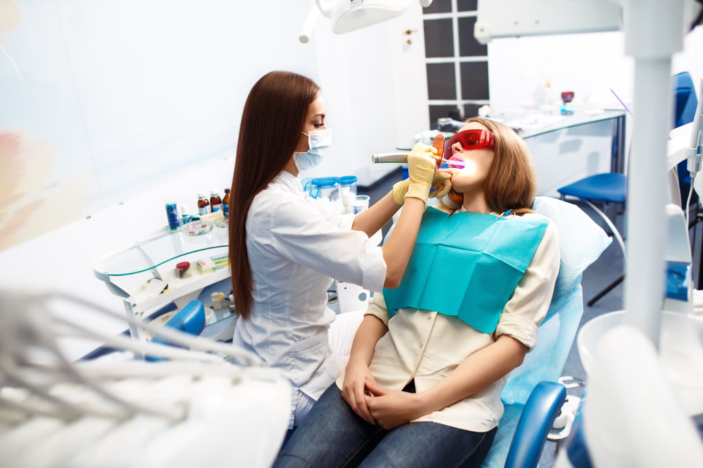 Overview of dental caries prevention.Woman at the dentist's chair during a dental procedure. Beautiful Woman smile close up. Healthy Smile. Beautiful Female Smile